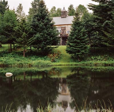 Diana's home, a reconstructed barn, peers through the trees and reflects off the pond, which is fed by a natural spring.